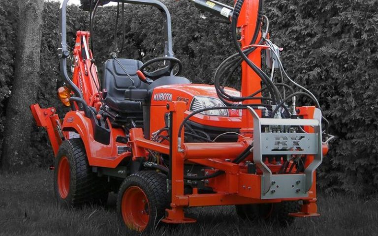 Mini excavatrice orange à l'arrêt sur un terrain